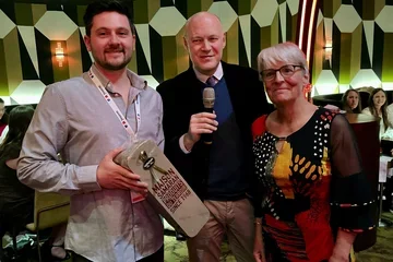 Gabriel Karin receiving the first prize souvenir from two organizers