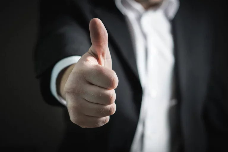 An outstreached arm gives a thumbs up.